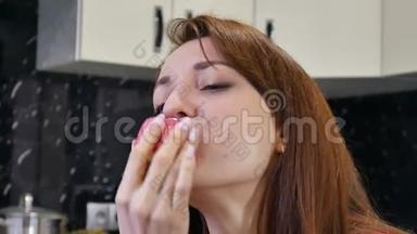疯狂饥饿的长发年轻女士在她家的厨房里吃一块蛋糕。 糖瘾问题